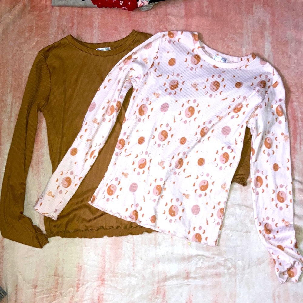 A pink ying-yang shirt that is pair with a brown shirt from the brand yummy soft